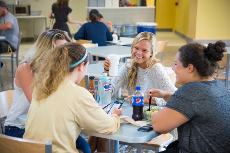 Al soggiorno linguistico inglese New York delle ragazze stanno facendo pranzo nella mensa della scuola