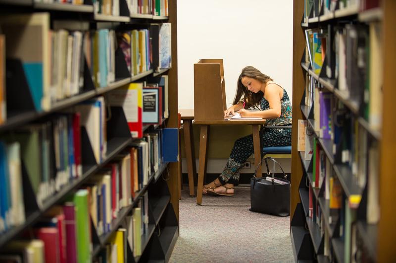 Al soggiorno linguistico inglese New York una ragazza sta studiando in biblioteca