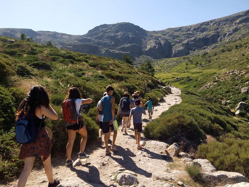 Un gruppo di ragazzi cammina su un sentiero davanti alle dei viaggi organizzati Piemonte