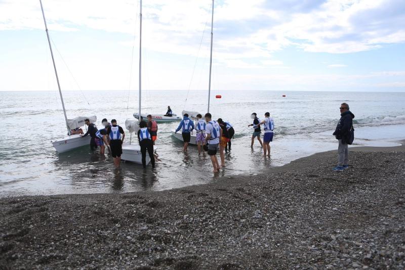 gruppo di ragazzi si accinge ad entrare in acqua per una lezione di vela con le barche a vela