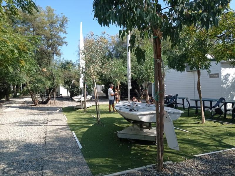 Giardino dell'alloggio ai campi estivi Basilicata con una casetta e due barche a vela in giardino